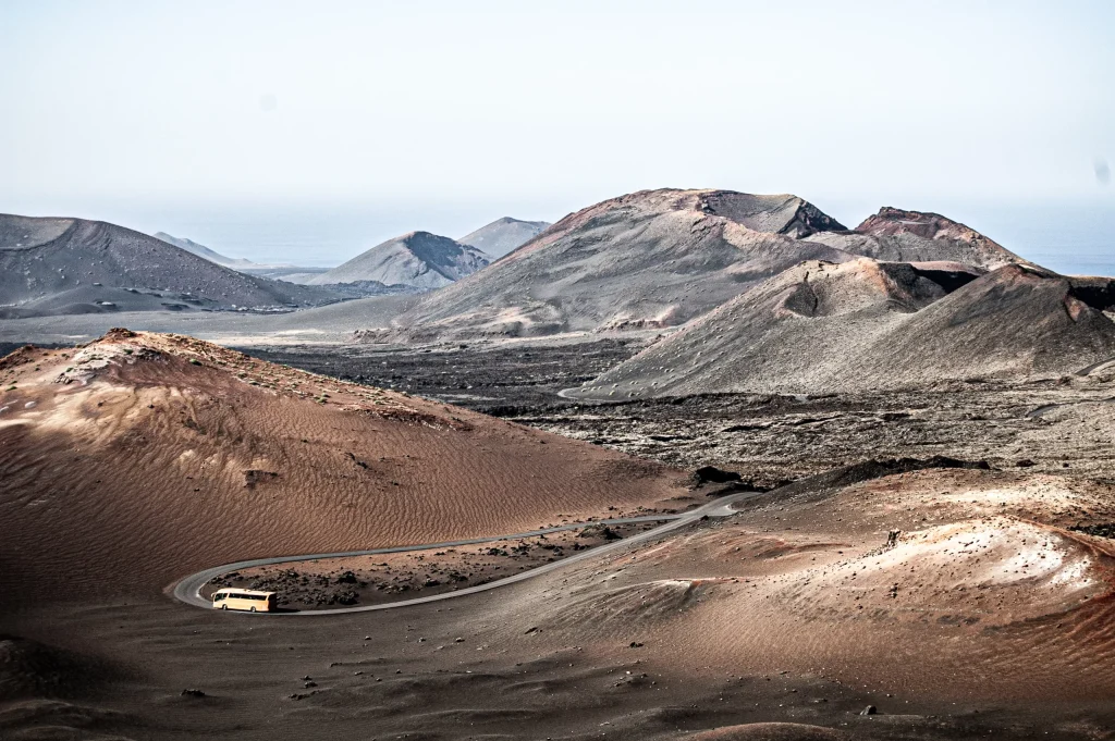 Panorámica de un autobús surcando una de las carreteras que dan forma a la isla de Lanzarote.